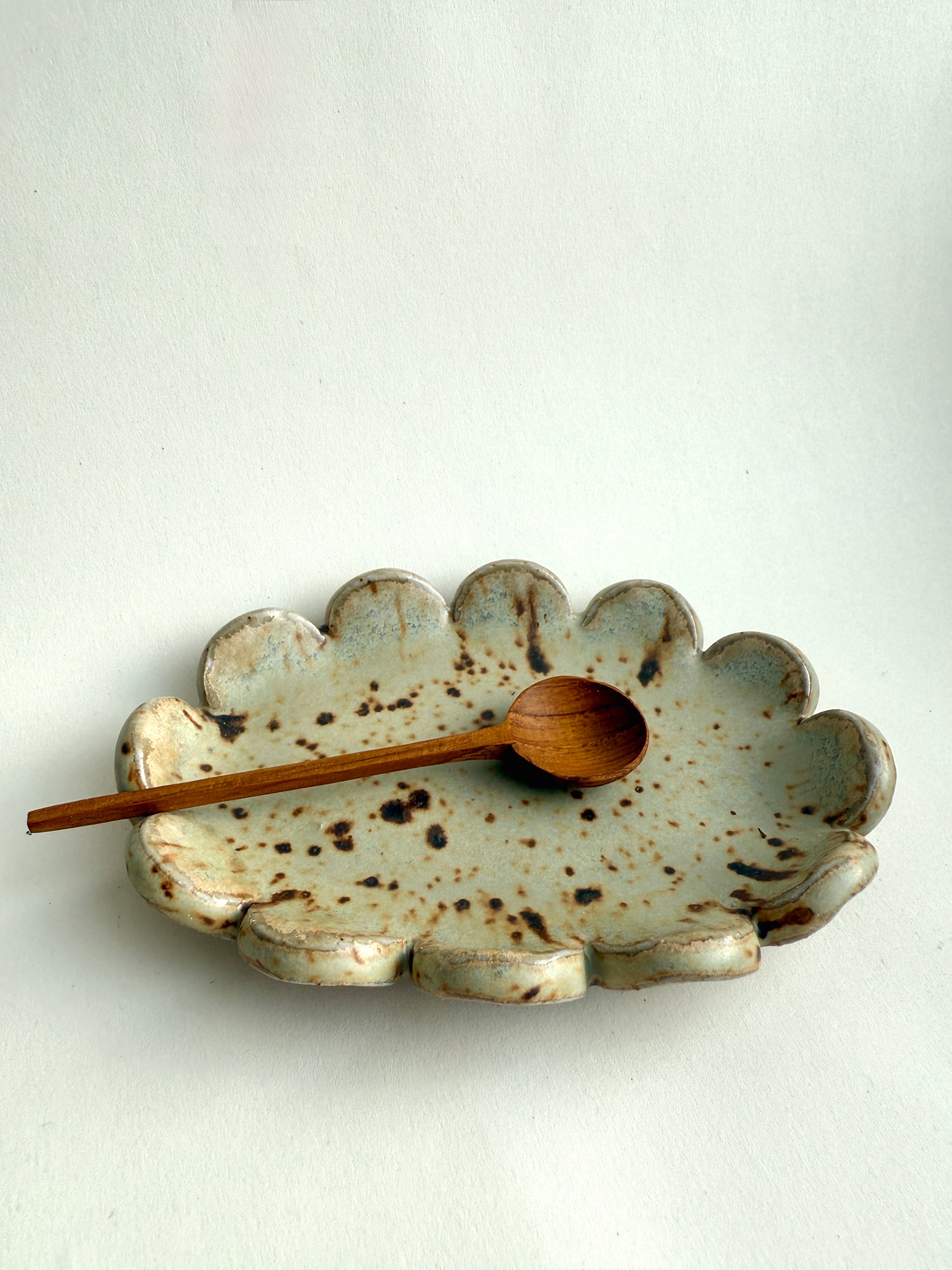 Scalloped speckled ceramic trinket tray with handmade organic edges.