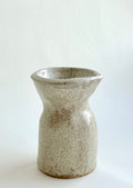 Handbuilt stone-textured ceramic mini vase with mottled beige and grey glaze and soft hourglass shape