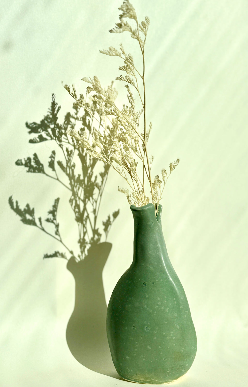 handbuilt green stoneware vase with organic shape bunzy ceramics vase in soft green glaze with dried florals