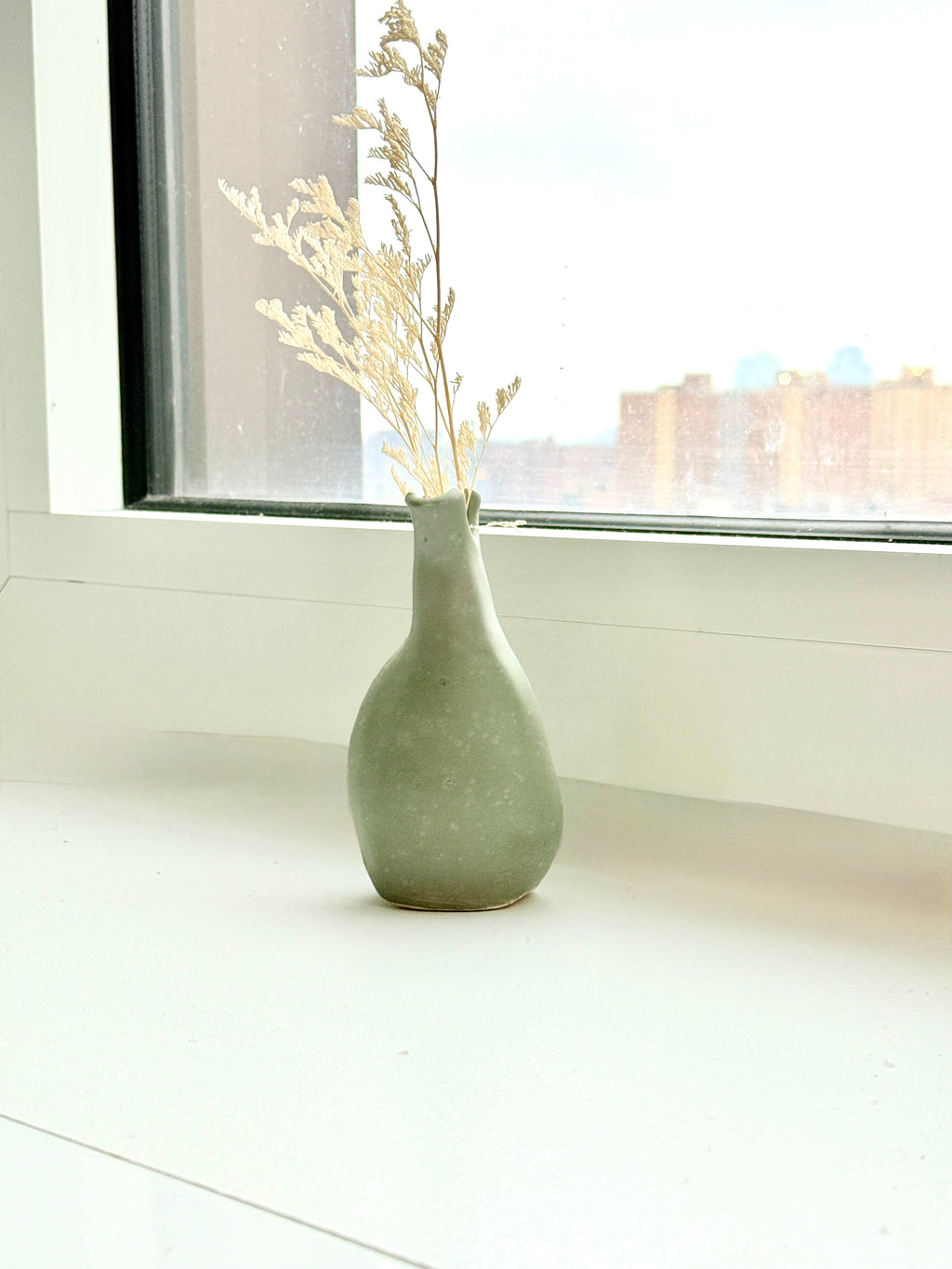 handbuilt green stoneware vase with organic shape bunzy ceramics vase in soft green glaze with dried florals