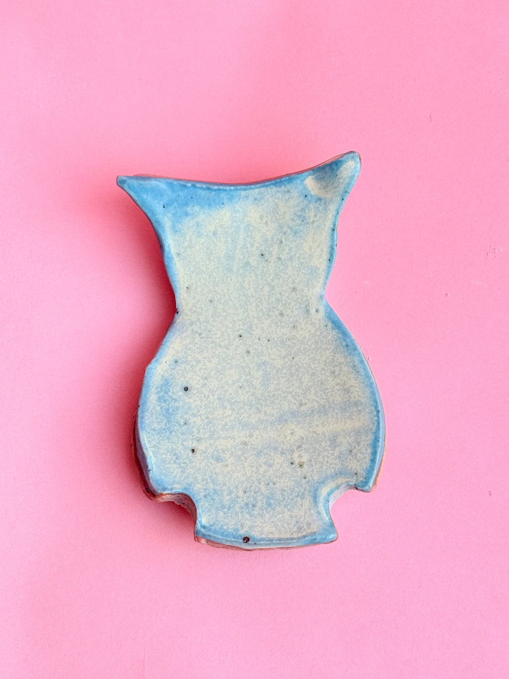 Handmade blue ceramic owl trinket tray on pink background