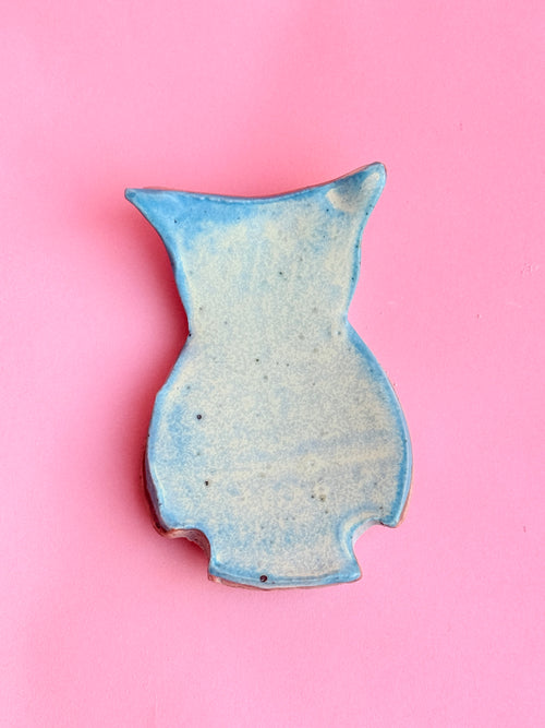 Handmade blue ceramic owl trinket tray on pink background