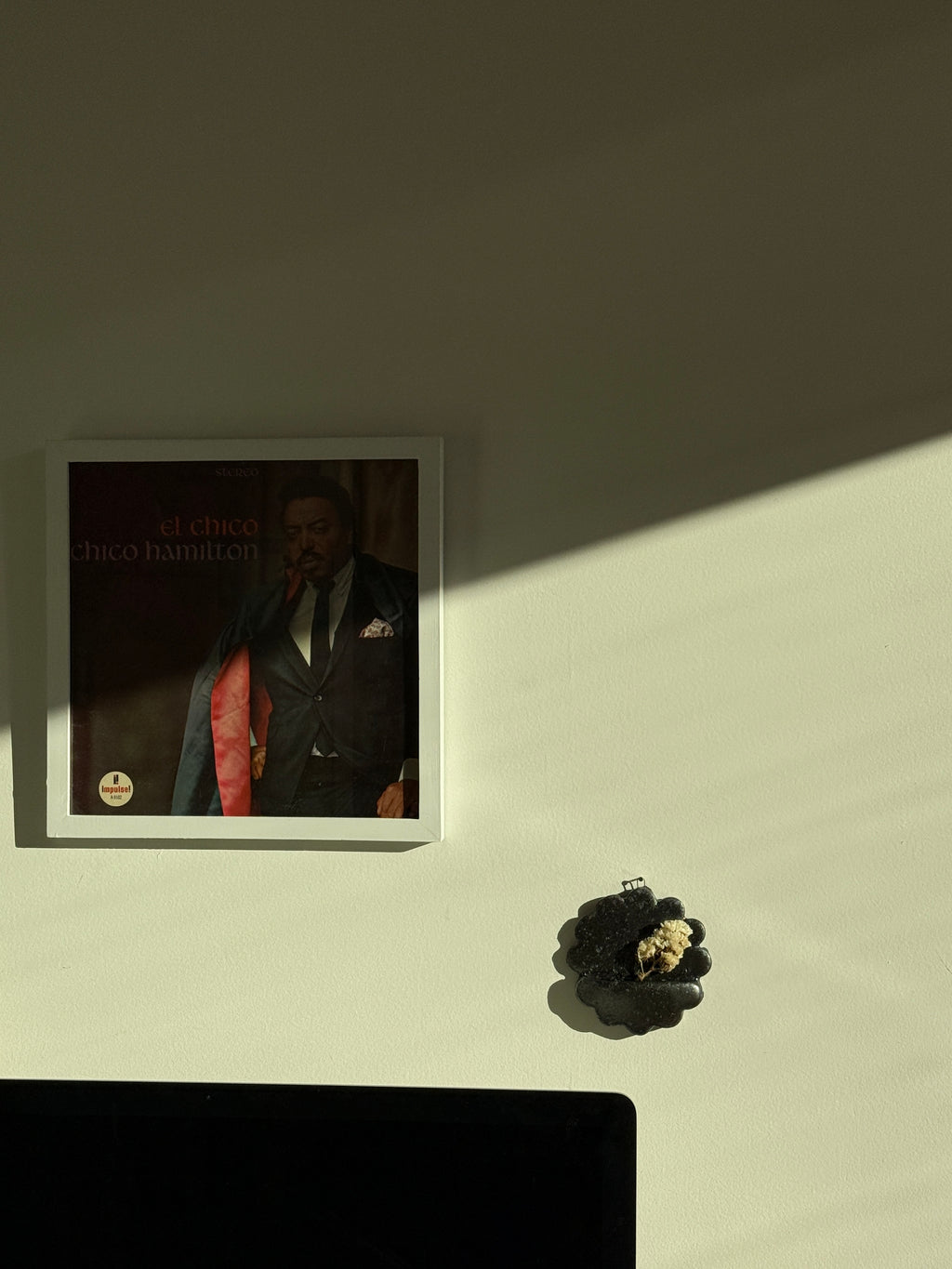 Black speckled ceramic wall pocket with dried floral arrangement