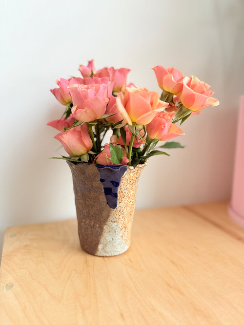 Hand-built stoneware cup with creamy speckled glaze and subtle blue with pink flowers