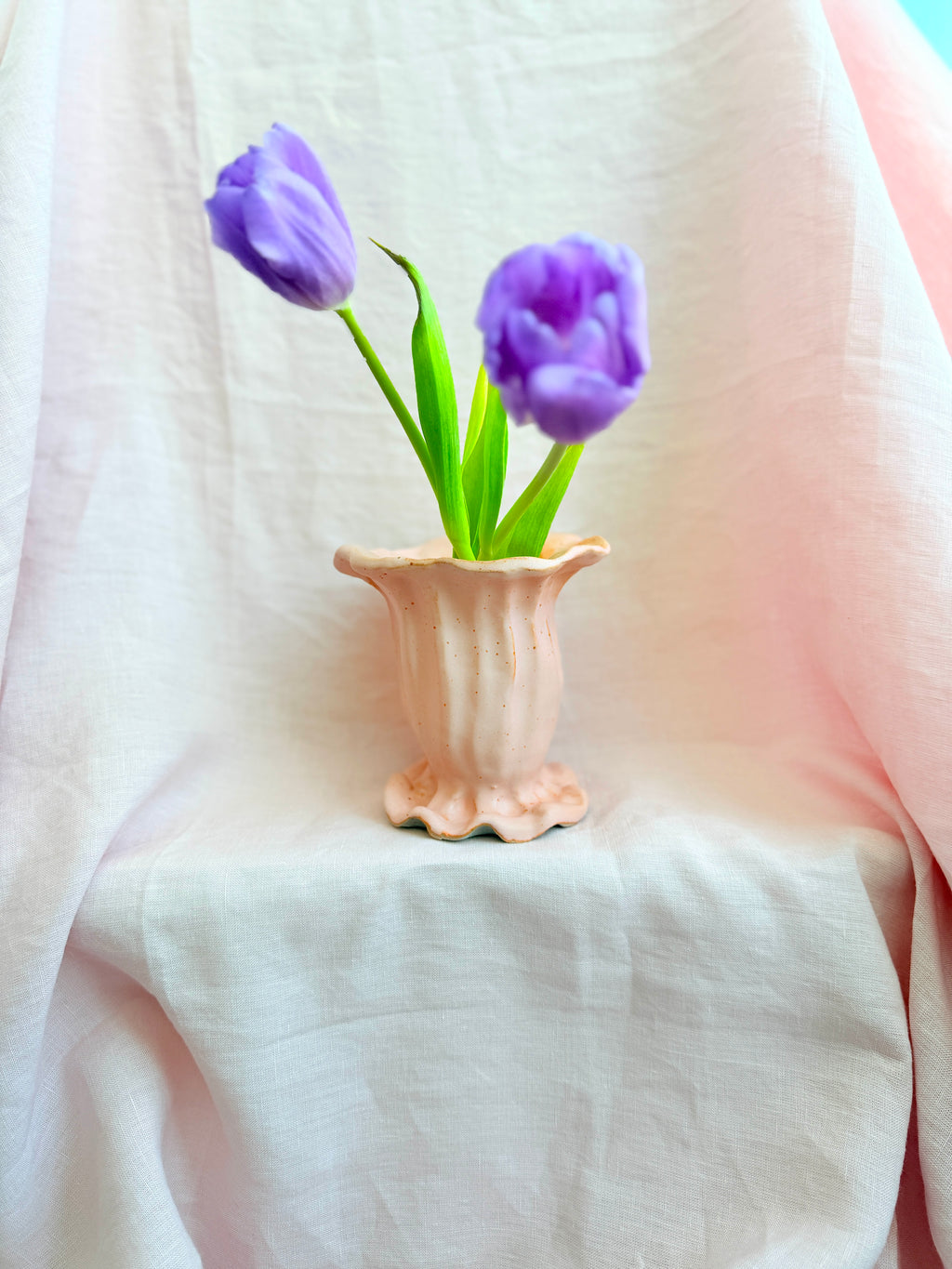 Vase with purple tulips on a soft white background