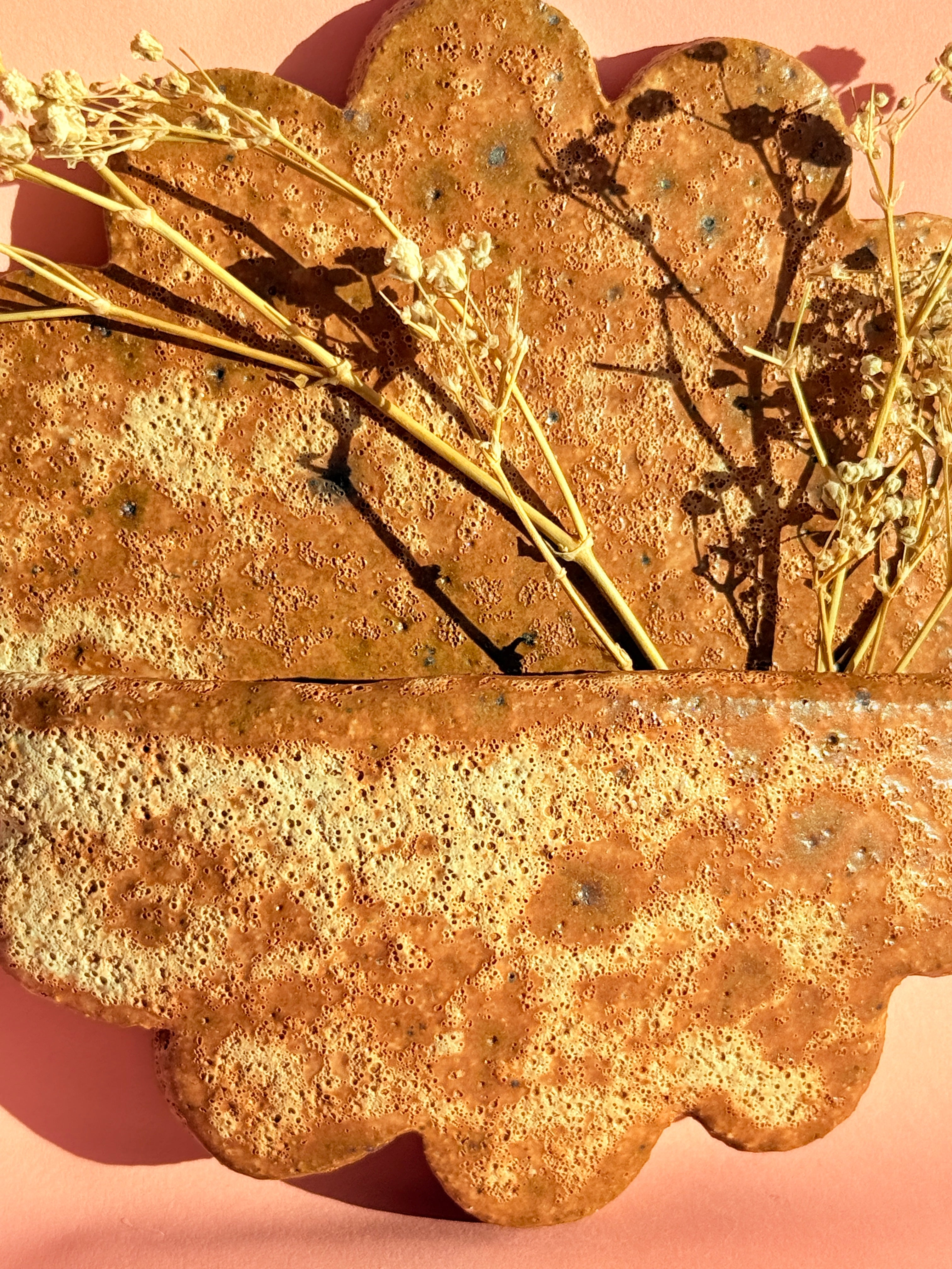 Close-up of textured handmade ceramic wall pocket with natural speckled glaze