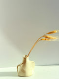 White vase with dried flowers on gray background