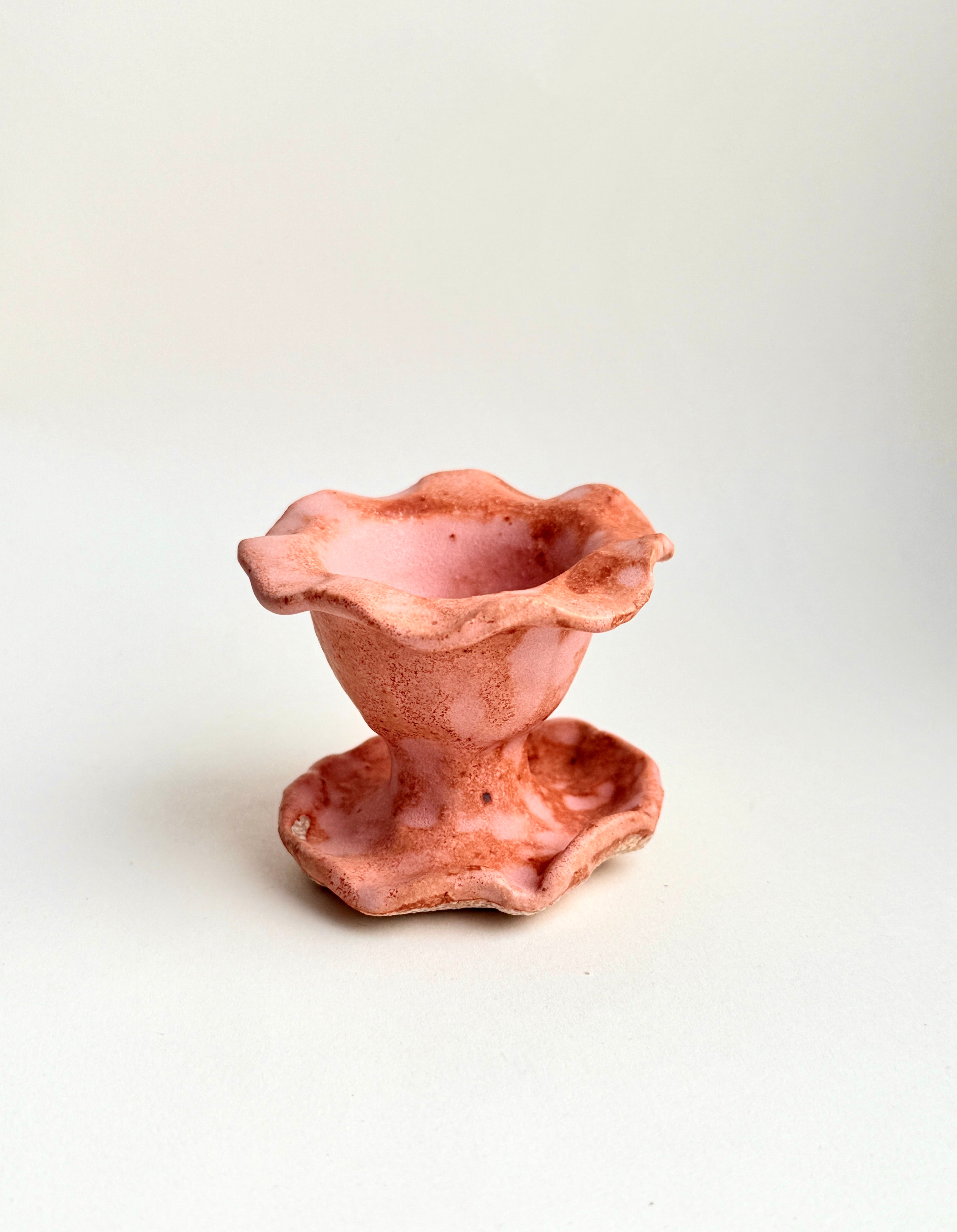 Hand-built stoneware pink pedestal incense cone holder with sculptural ruffled edges and organic form