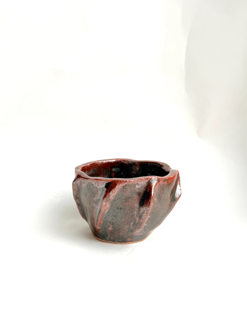 Hand-built stoneware cup with earthy brown glaze, organic shape