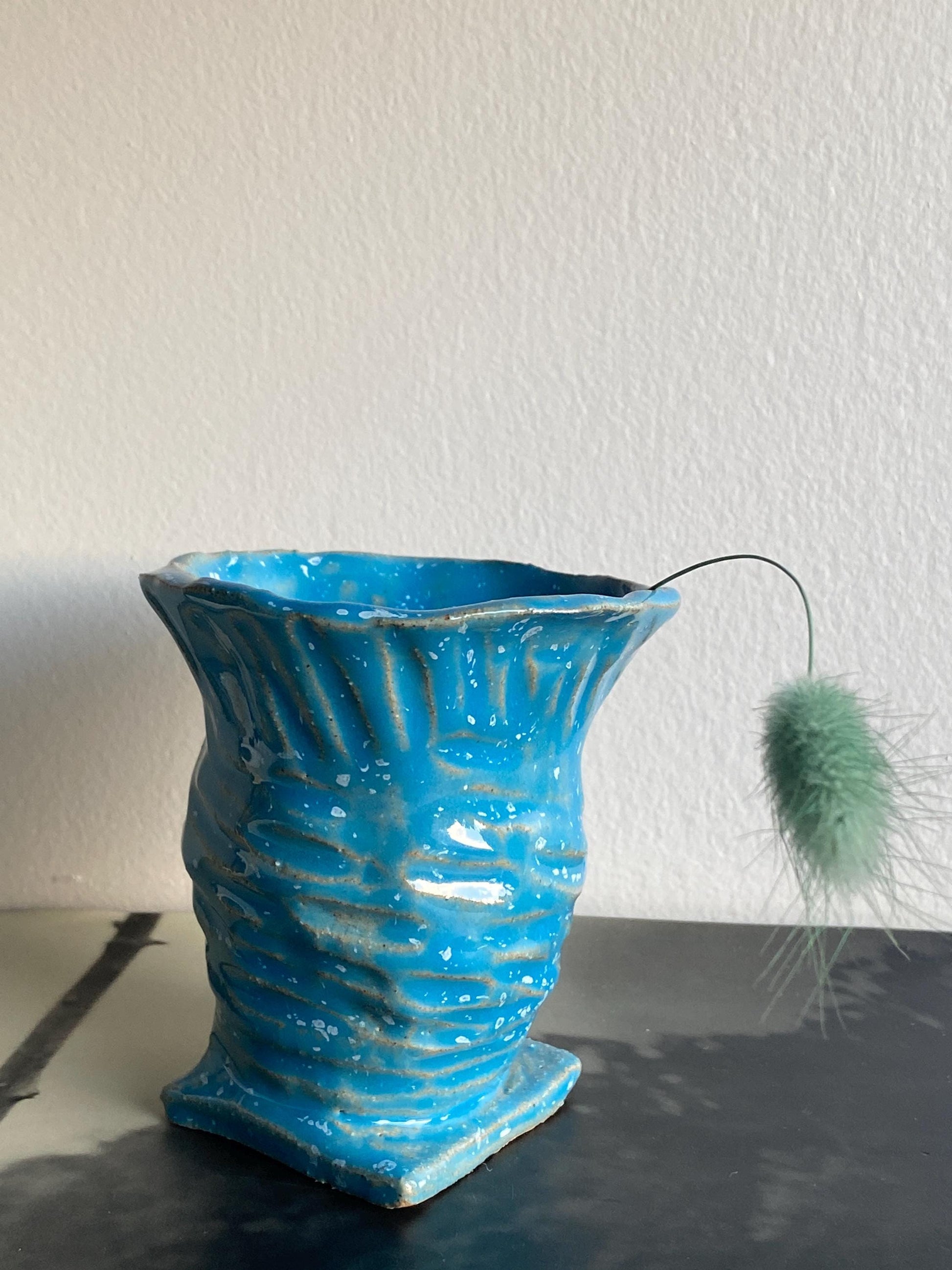 Small blue speckled ceramic vase, perfect for displaying flowers or as a decorative accent piece in modern home decor.