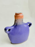 Hand-built stoneware bud vase with soft lavender glaze and pink rim, speckled surface, and small side handles 